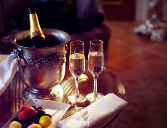 Champagne mit zwei vollen Gläsern auf einem Glastisch