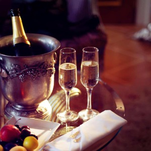 Champagne mit zwei vollen Gläsern auf einem Glastisch